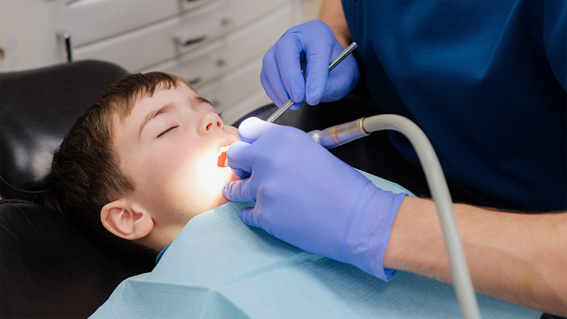 Emergency Pediatric Dental Care in Alabaster Alabama. A dentist works on a child's teeth with specialized tools.