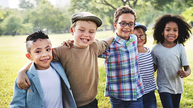 Pediatric Dental Care. A group of children smile and walk through a park arm in arm. Confident smiles brought to you by Alabaster Smiles Pediatric Dentistry.