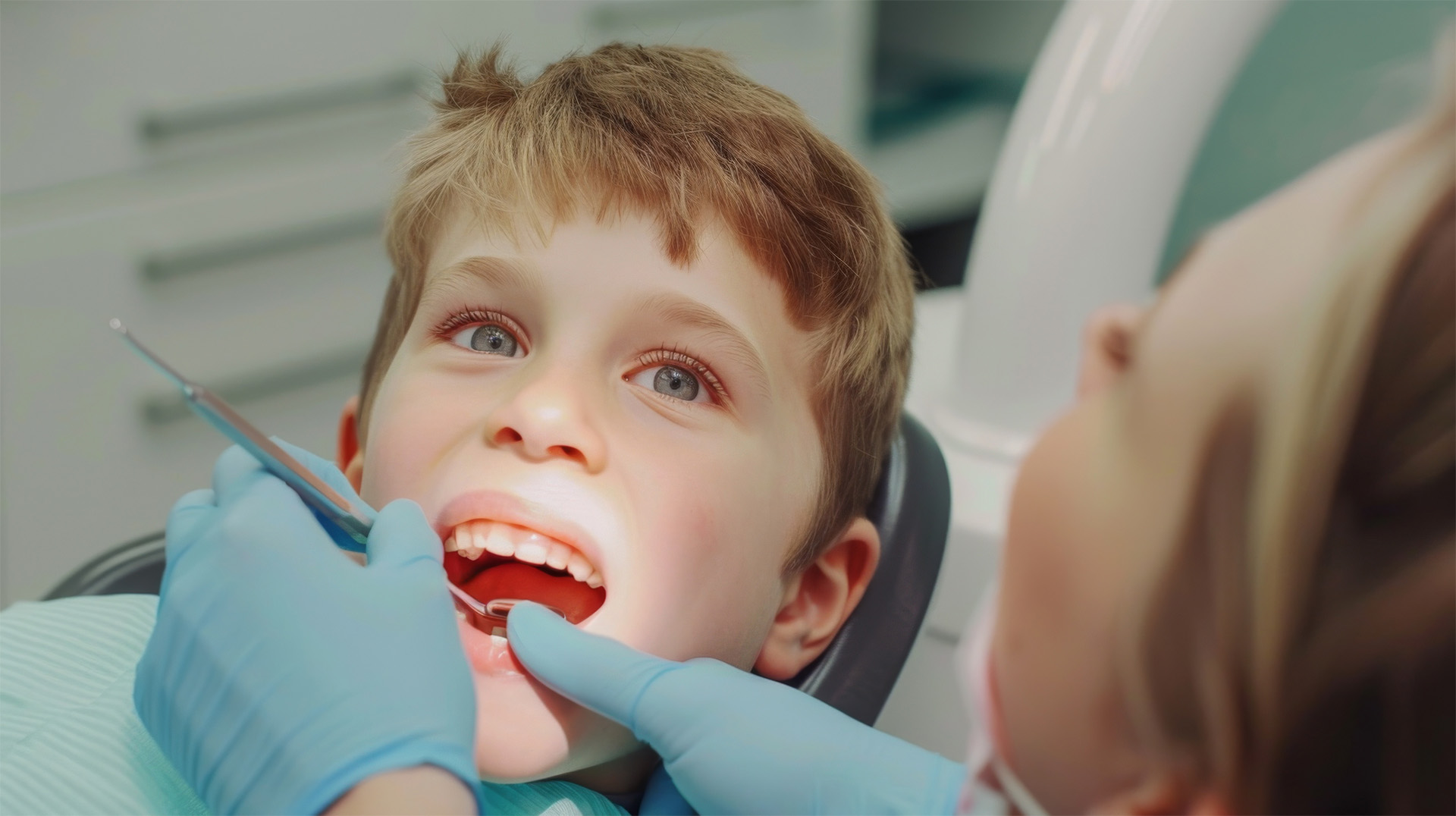 Pediatric Dental Services. A happy child looks up while a dentist performs an exam.