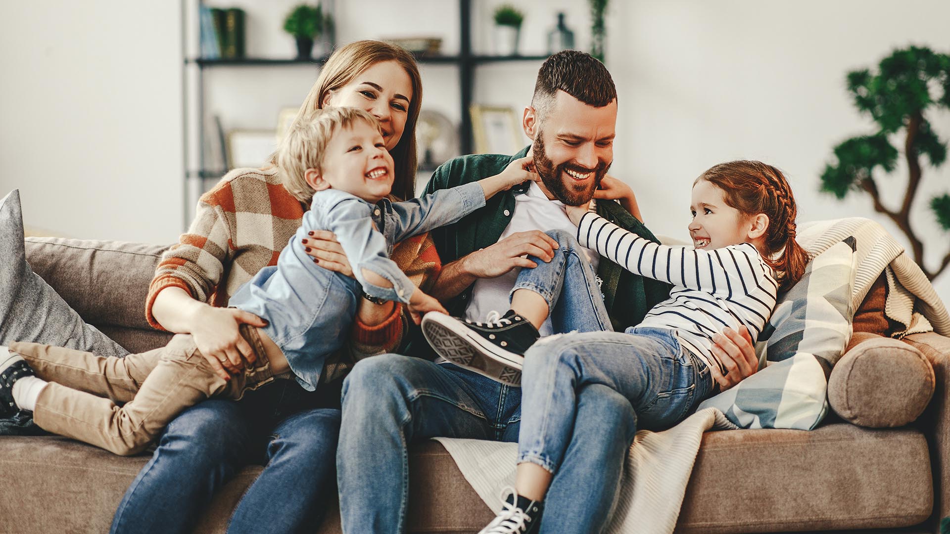 Pediatric Dentist Financial Options. A happy family plays in their living room.